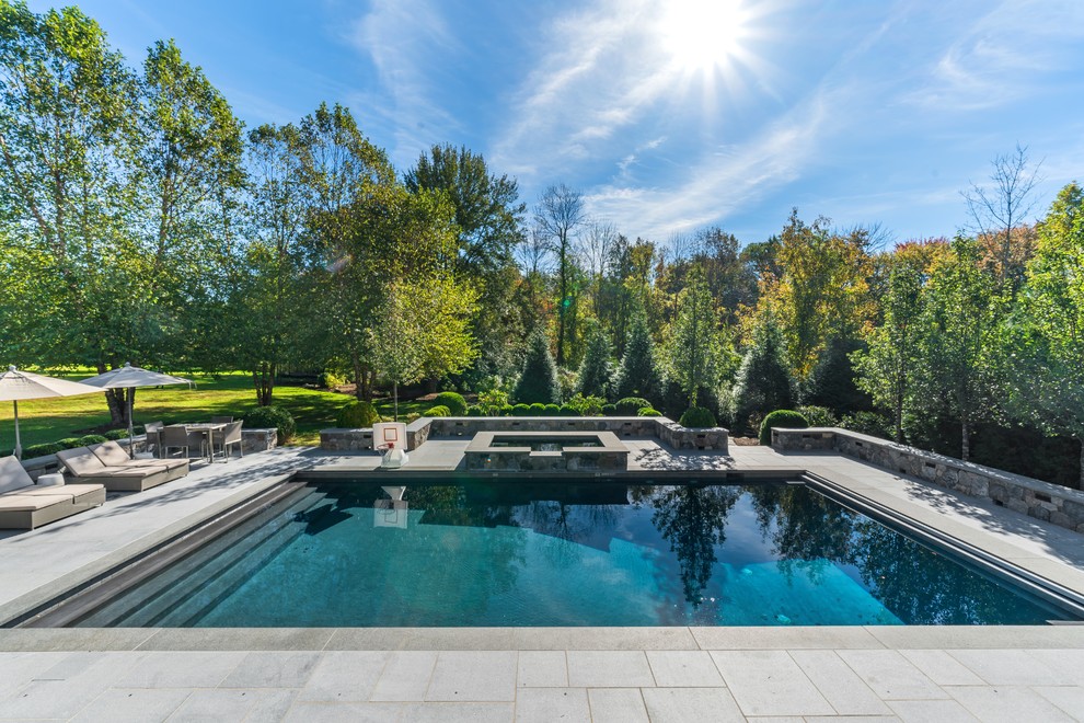 Inspiration for a transitional backyard rectangular lap pool in New York with a hot tub and concrete pavers.