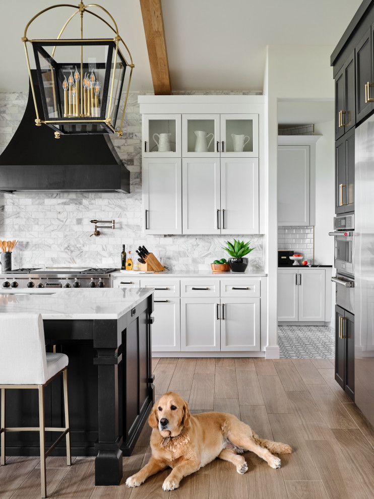 Open concept kitchen - huge farmhouse l-shaped porcelain tile, beige floor and vaulted ceiling open concept kitchen idea in Omaha with an undermount sink, shaker cabinets, black cabinets, quartz countertops, gray backsplash, marble backsplash, stainless steel appliances, an island and white countertops