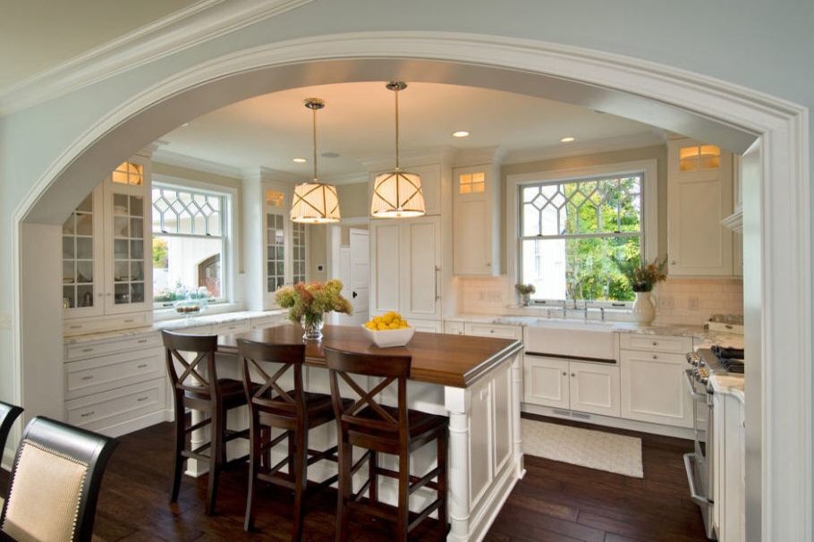 Large transitional u-shaped dark wood floor and brown floor kitchen photo in DC Metro with a farmhouse sink, recessed-panel cabinets, white cabinets, quartzite countertops, white backsplash, subway tile backsplash, paneled appliances and an island