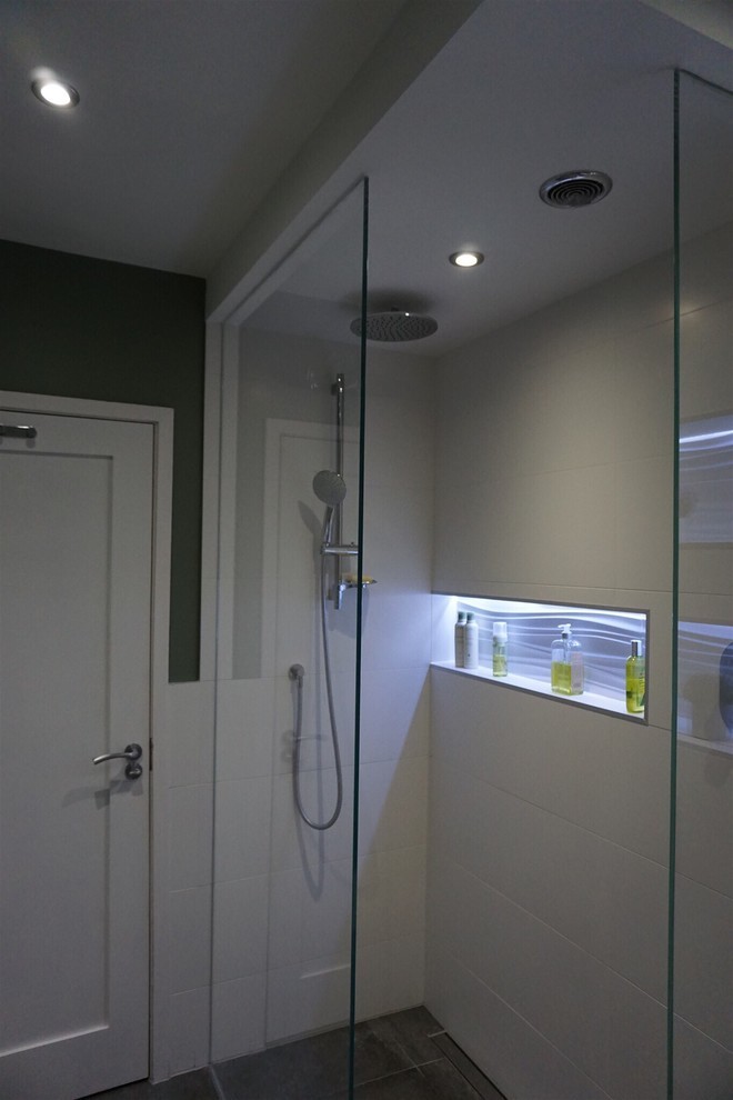 This is an example of a 3/4 wet room bathroom in Dublin with medium wood cabinets, a wall-mount toilet, white tile, ceramic tile, green walls, porcelain floors, a wall-mount sink, grey floor and an open shower.