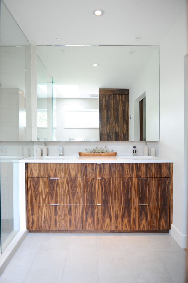 Photo of a mid-sized modern master bathroom in Vancouver with an undermount sink, flat-panel cabinets, dark wood cabinets, white walls, porcelain floors, solid surface benchtops, grey floor and white benchtops.