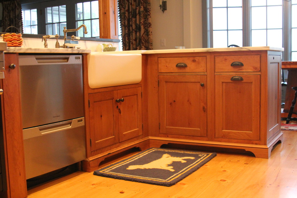 Example of a large transitional galley eat-in kitchen design in Boston with a farmhouse sink, recessed-panel cabinets, medium tone wood cabinets, marble countertops, stainless steel appliances and a peninsula