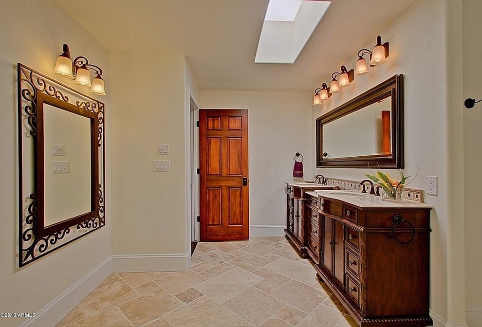 Inspiration for a large country 3/4 bathroom in Phoenix with an undermount sink, raised-panel cabinets, medium wood cabinets, marble benchtops, a one-piece toilet, white tile, stone slab, white walls and travertine floors.