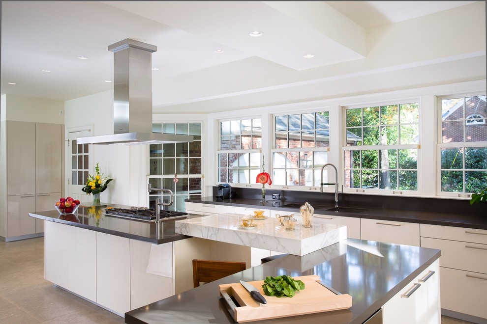 Expansive contemporary l-shaped separate kitchen in Atlanta with a double-bowl sink, flat-panel cabinets, beige cabinets, quartz benchtops, travertine floors, multiple islands and stainless steel appliances.