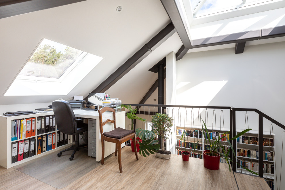 Design ideas for a large contemporary home office in Berlin with white walls, vinyl floors, a freestanding desk and brown floor.