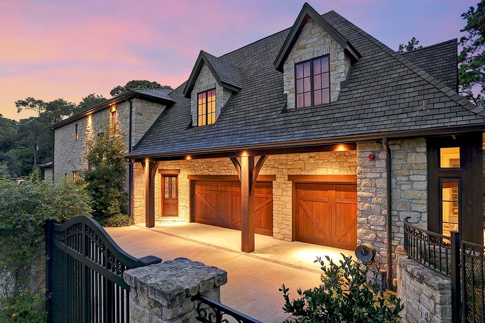 Inspiration for a large country two-storey grey exterior in Houston with stone veneer and a gable roof.