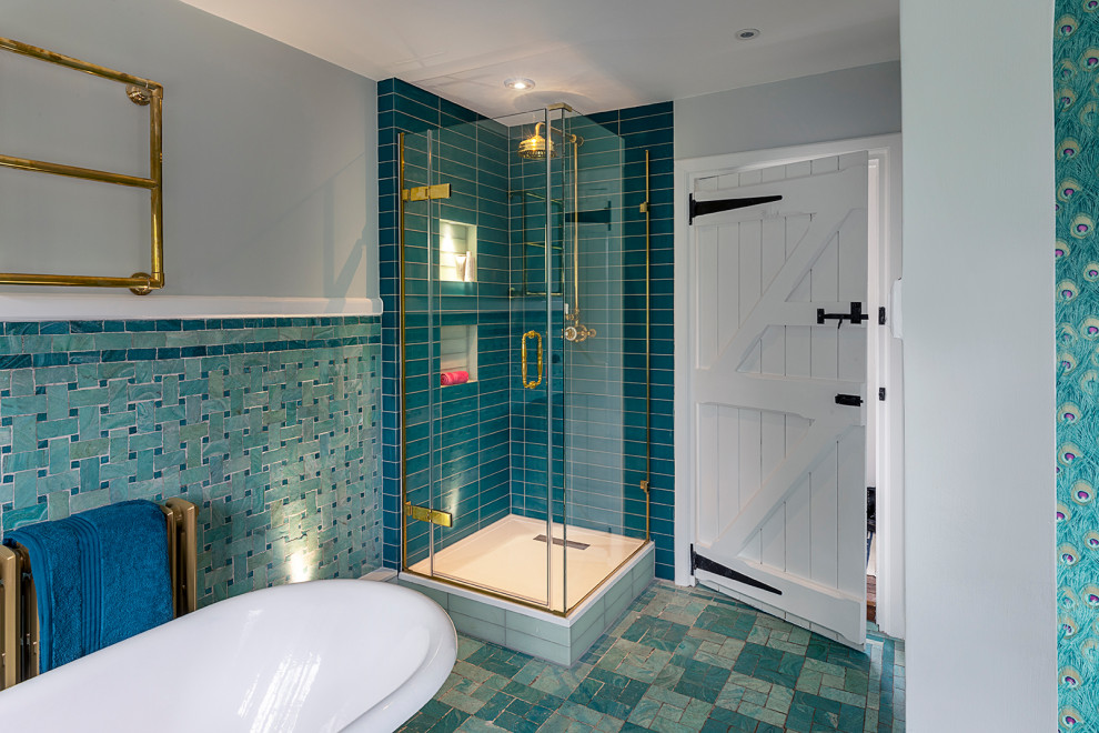 This is an example of a mid-sized contemporary kids bathroom in Oxfordshire with blue cabinets, a freestanding tub, a corner shower, blue tile, ceramic tile, blue walls, ceramic floors, blue floor, a hinged shower door, wallpaper and wallpaper.