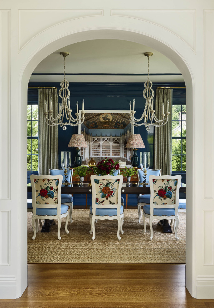 Rye Colonial - Example of a classic medium tone wood floor, brown floor and wall paneling enclosed dining room design in New York with blue walls