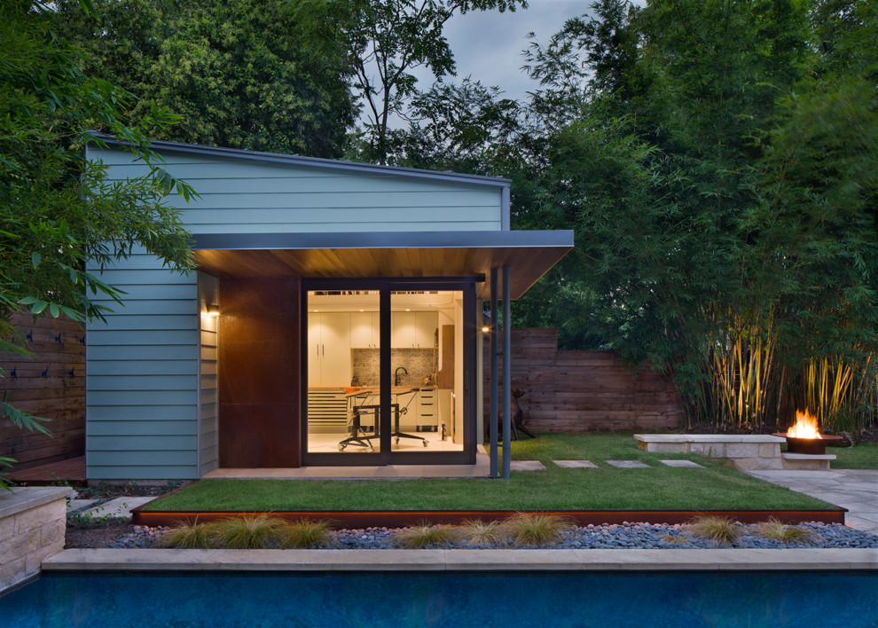 Photo of a small contemporary one-storey green exterior in Austin with concrete fiberboard siding and a shed roof.