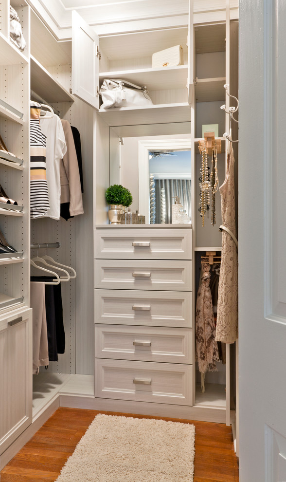 Transitional women's walk-in wardrobe in Other with recessed-panel cabinets, white cabinets and medium hardwood floors.