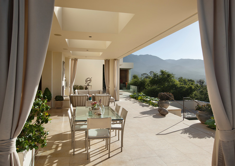 Design ideas for a large mediterranean backyard deck in Santa Barbara with a roof extension.
