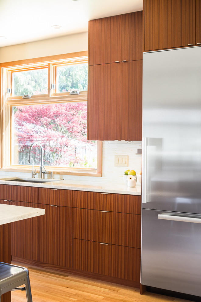 Design ideas for a mid-sized modern u-shaped eat-in kitchen in Seattle with an undermount sink, flat-panel cabinets, medium wood cabinets, quartz benchtops, stainless steel appliances, light hardwood floors and with island.