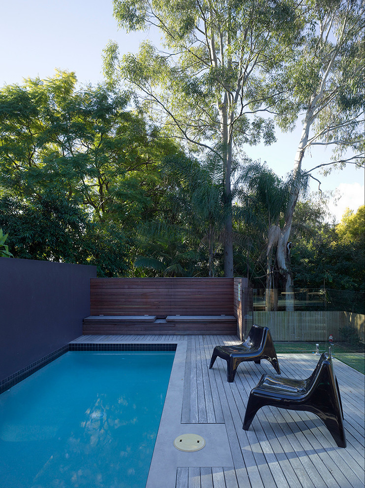 This is an example of a contemporary backyard rectangular lap pool in Brisbane with decking.