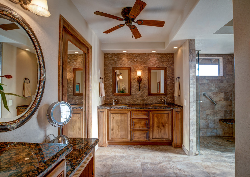 Design ideas for a large traditional master bathroom in Los Angeles with raised-panel cabinets, medium wood cabinets, an alcove shower, a two-piece toilet, brown tile, stone tile, beige walls, ceramic floors, a drop-in sink and granite benchtops.