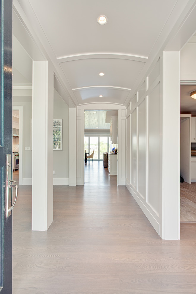 Inspiration for a large transitional hallway in Other with white walls, light hardwood floors and brown floor.