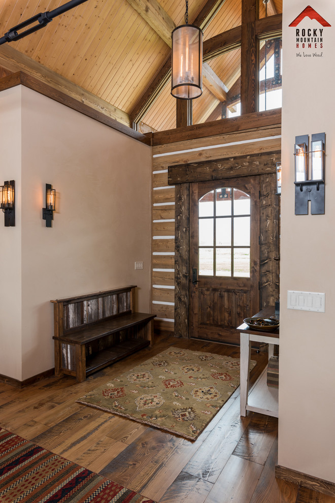 Foyer - mid-sized rustic medium tone wood floor and brown floor foyer idea with white walls and a dark wood front door