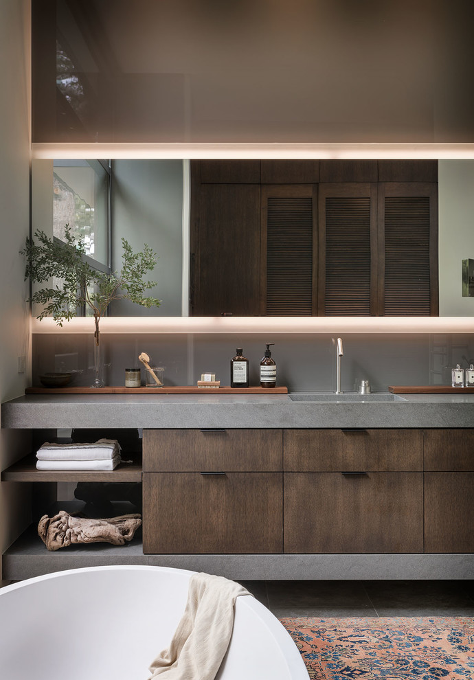 Photo of a midcentury master bathroom in Orange County with flat-panel cabinets, grey walls, an integrated sink, grey benchtops and dark wood cabinets.