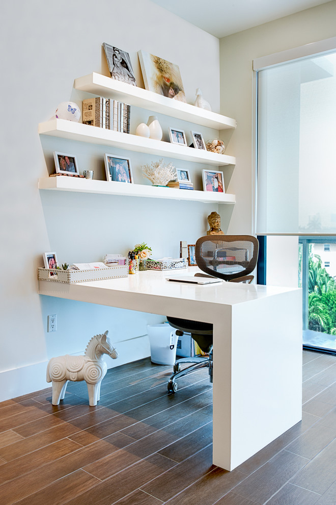 This is an example of a mid-sized contemporary study room in Miami with white walls, porcelain floors and a built-in desk.