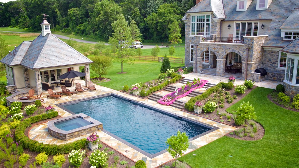 Inspiration for a large traditional backyard rectangular lap pool in Philadelphia with a hot tub and natural stone pavers.