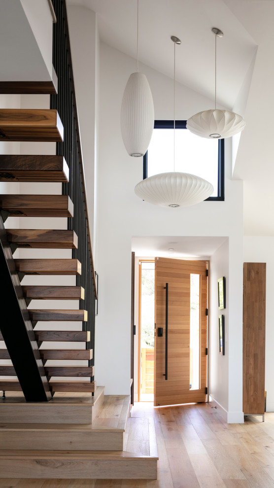Mittelgroße Moderne Haustür mit weißer Wandfarbe, braunem Holzboden, Einzeltür, heller Holzhaustür, beigem Boden und gewölbter Decke in Orange County