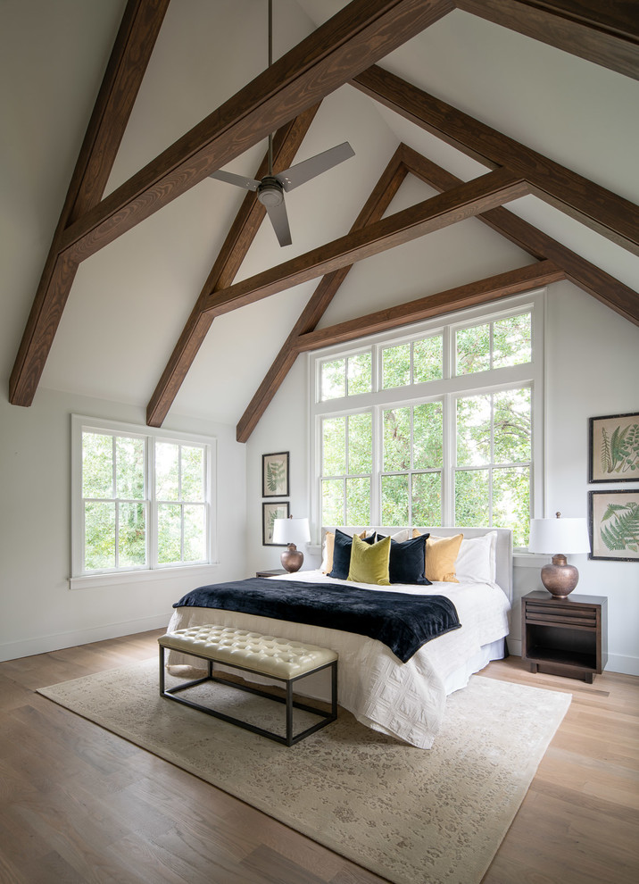 Inspiration for a country bedroom in Atlanta with white walls, medium hardwood floors and brown floor.