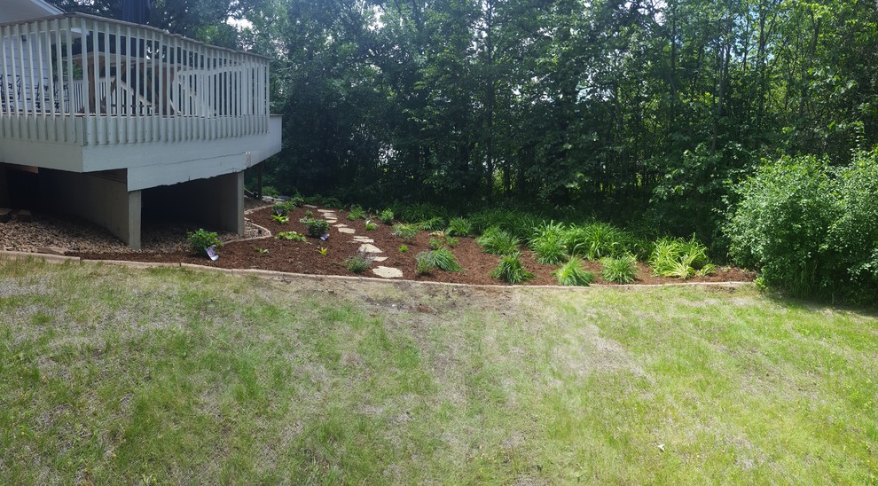 Photo of a transitional partial sun hillside stone landscaping for summer.