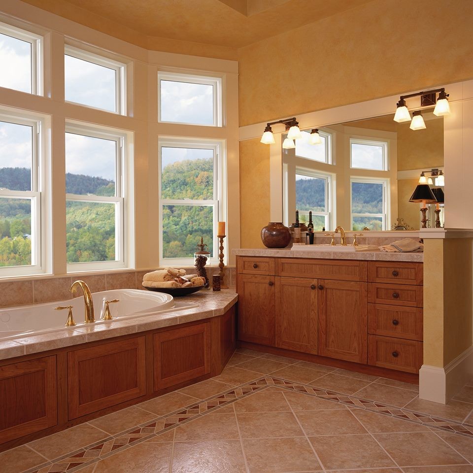 This is an example of a large traditional master bathroom in New York with recessed-panel cabinets, light wood cabinets, a drop-in tub, ceramic tile, yellow walls and ceramic floors.