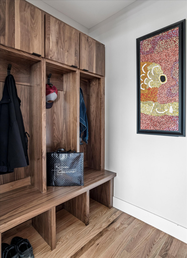 Immagine di un piccolo ingresso con anticamera minimalista con pareti grigie, pavimento in legno massello medio, una porta singola, una porta nera, pavimento marrone e soffitto a volta
