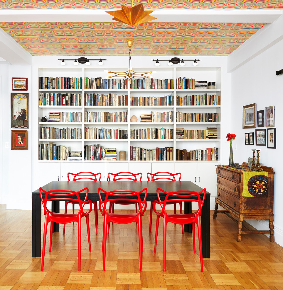 This is an example of a mid-sized eclectic dining room in New York with white walls, no fireplace and medium hardwood floors.