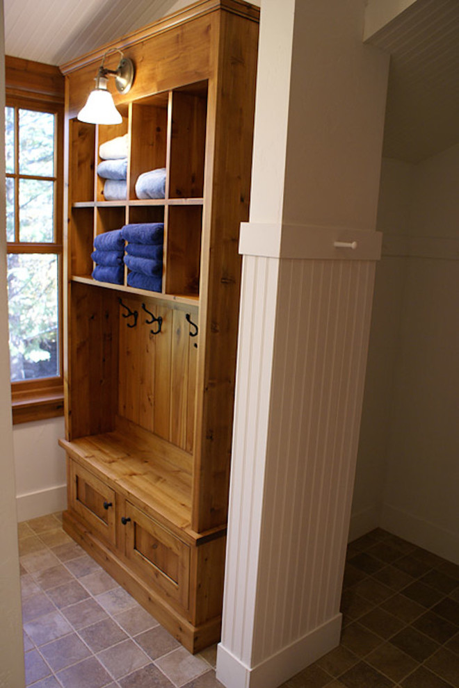 Example of a mid-sized ceramic tile mudroom design with white walls