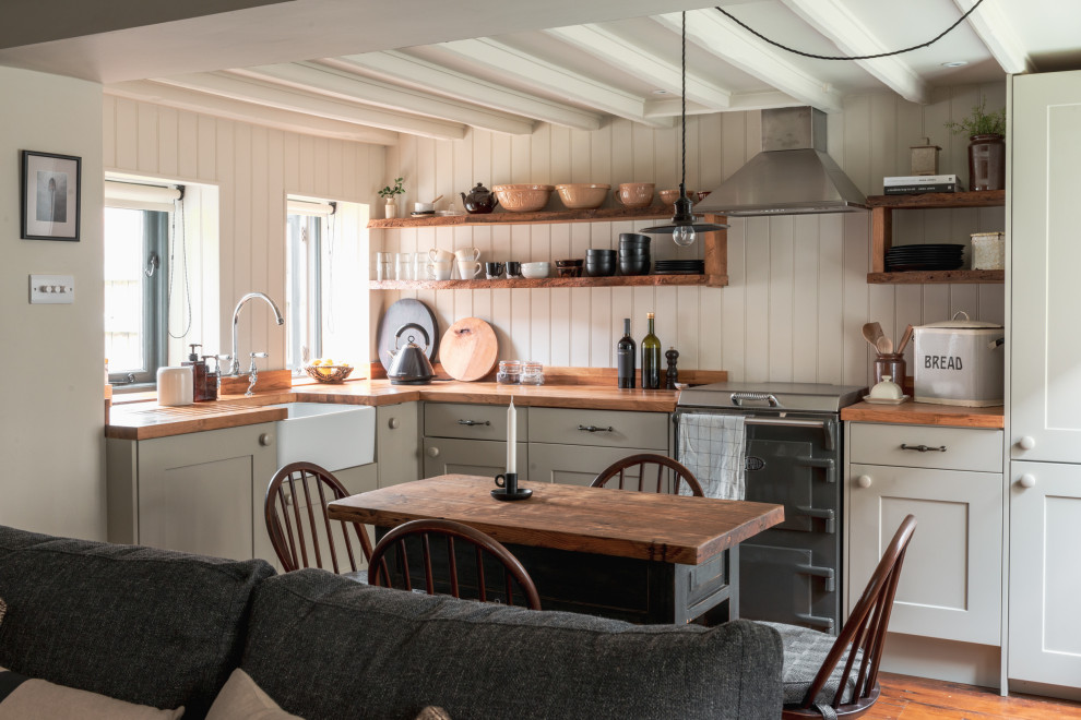 Design ideas for a country l-shaped kitchen in Other with a farmhouse sink, shaker cabinets, wood benchtops and exposed beam.