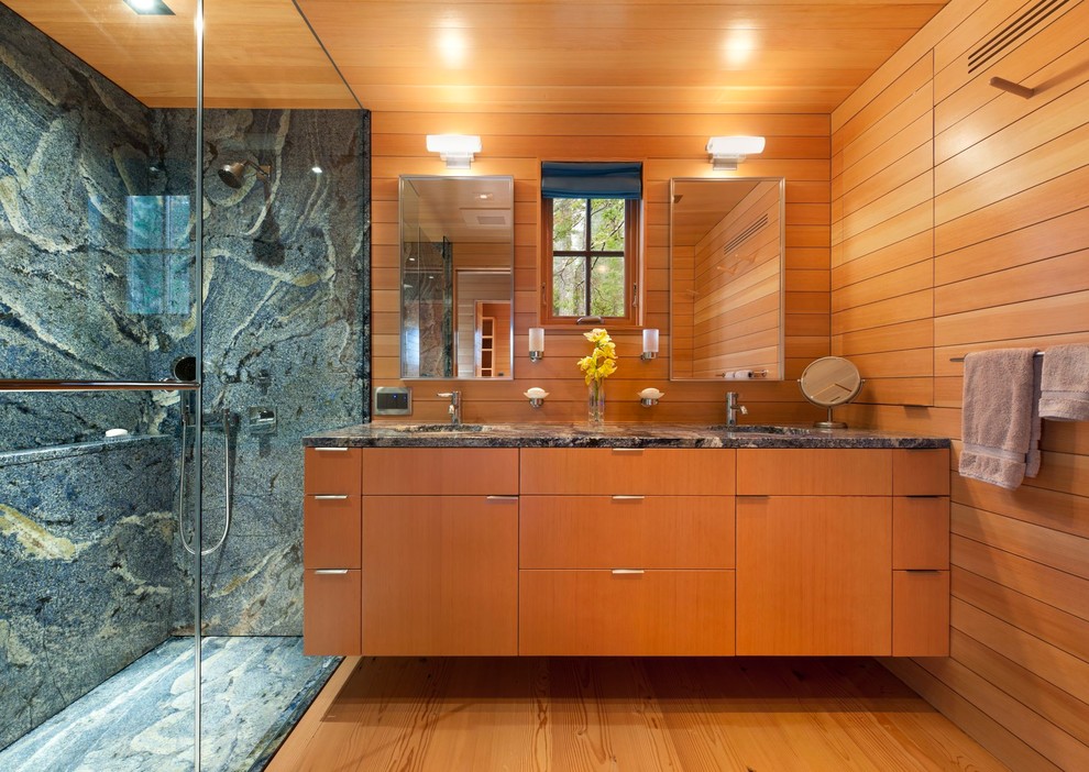 This is an example of a small modern master bathroom in Portland Maine with an undermount sink, flat-panel cabinets, medium wood cabinets, granite benchtops, a double shower, a two-piece toilet, blue tile, stone slab and medium hardwood floors.