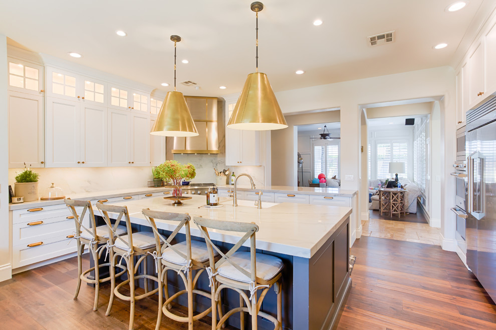Transitional u-shaped separate kitchen in Louisville with shaker cabinets, white cabinets, white splashback, stone slab splashback, stainless steel appliances, dark hardwood floors, with island and brown floor.