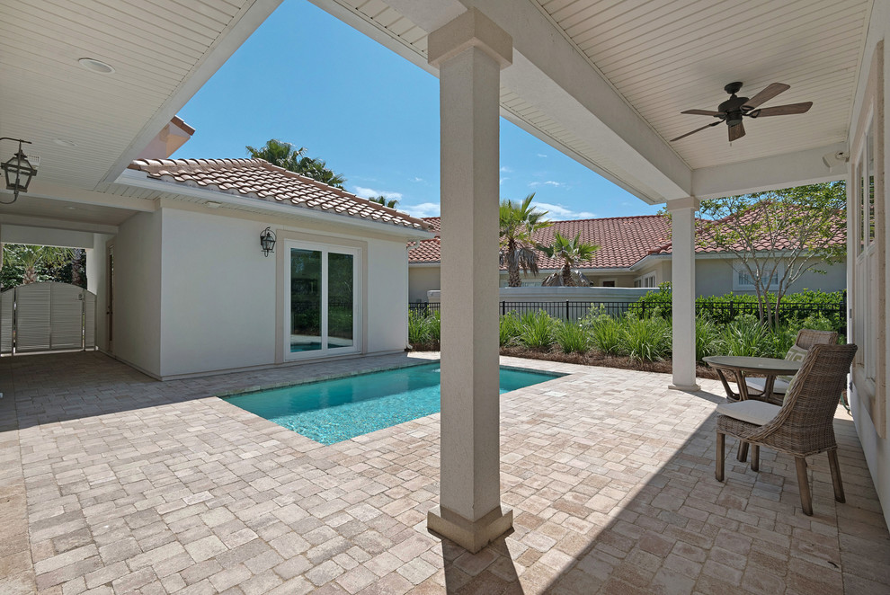 Inspiration for a small beach style courtyard rectangular natural pool in Miami with concrete pavers.