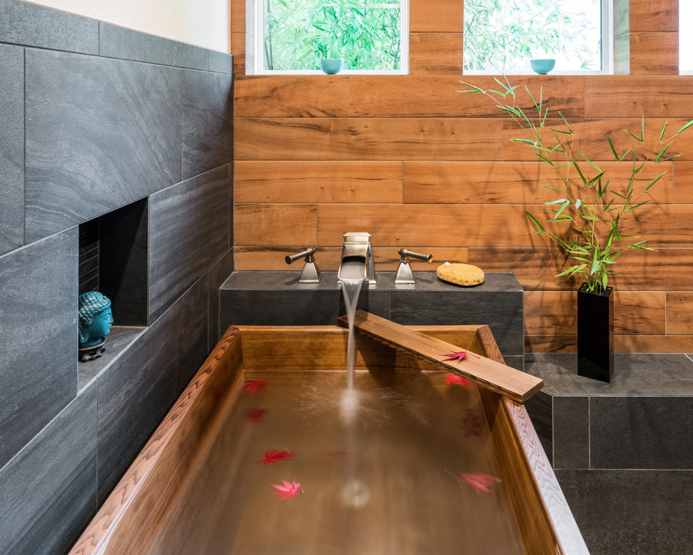 Photo of a transitional master bathroom in Portland with black tile, brown tile, a freestanding tub, an alcove shower, porcelain tile, beige walls, porcelain floors, beige floor and a hinged shower door.