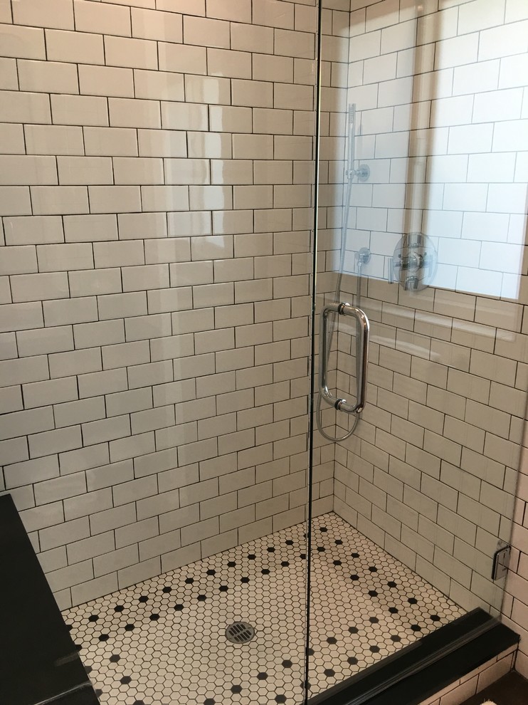 Inspiration for a mid-sized industrial bathroom in Los Angeles with open cabinets, medium wood cabinets, an alcove shower, a one-piece toilet, white tile, subway tile, white walls, ceramic floors, a trough sink and granite benchtops.