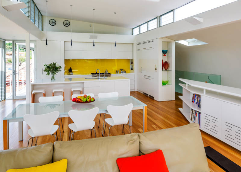 Design ideas for a mid-sized contemporary kitchen/dining combo in Sydney with white walls and medium hardwood floors.