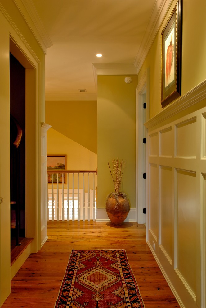 This is an example of a mid-sized beach style hallway in Charleston with beige walls, medium hardwood floors, brown floor and decorative wall panelling.