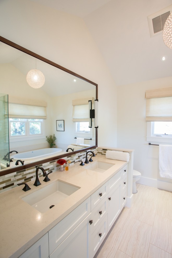 Photo of a mid-sized transitional master bathroom in San Francisco with an undermount sink, shaker cabinets, white cabinets, engineered quartz benchtops, an undermount tub, a corner shower, a one-piece toilet, multi-coloured tile, glass tile, beige walls and porcelain floors.