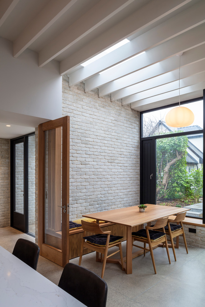 Contemporary kitchen/dining combo in Dublin with white walls, concrete floors and grey floor.