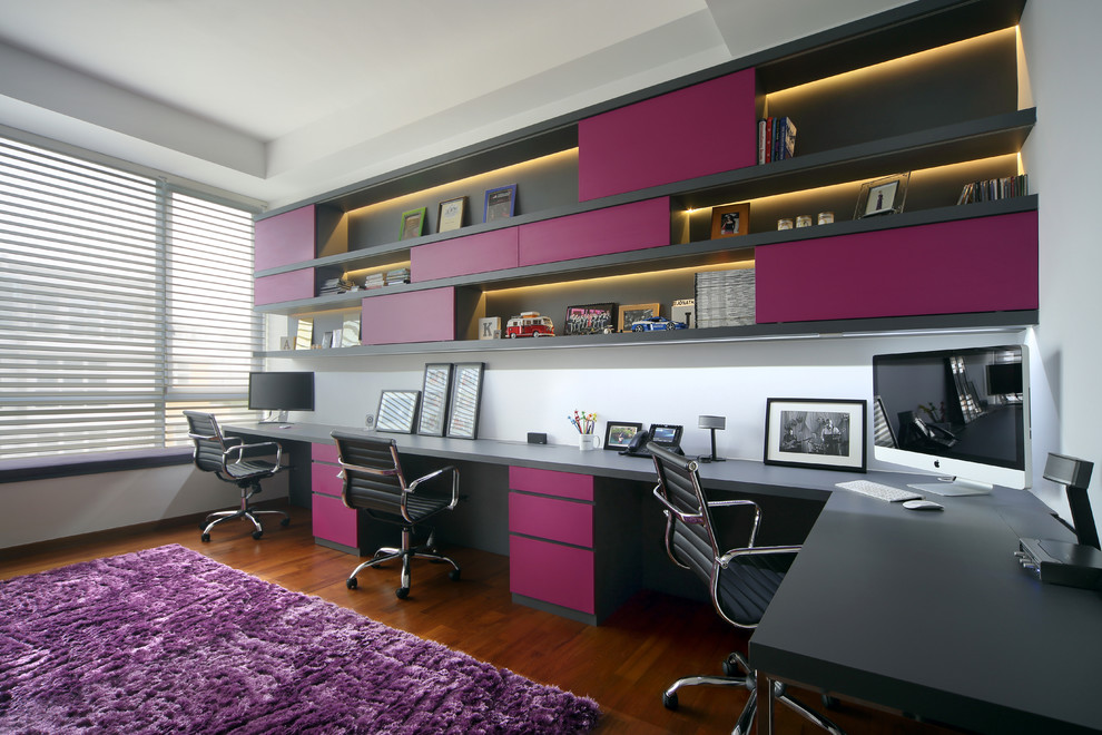 Contemporary home office in Singapore with white walls, dark hardwood floors, a built-in desk and brown floor.