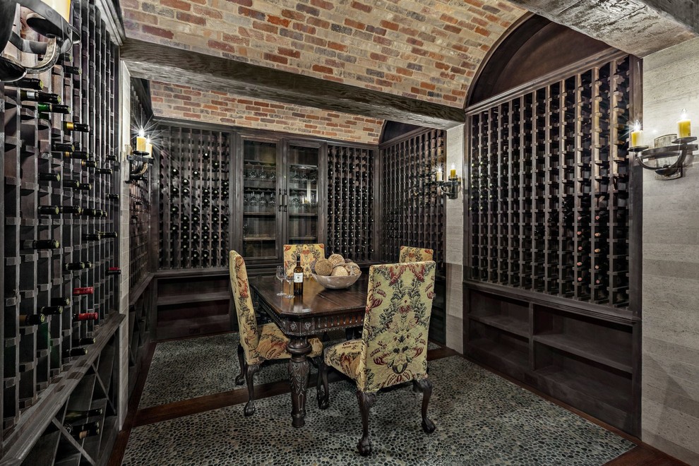This is an example of a large traditional wine cellar in Dallas with dark hardwood floors, storage racks and multi-coloured floor.
