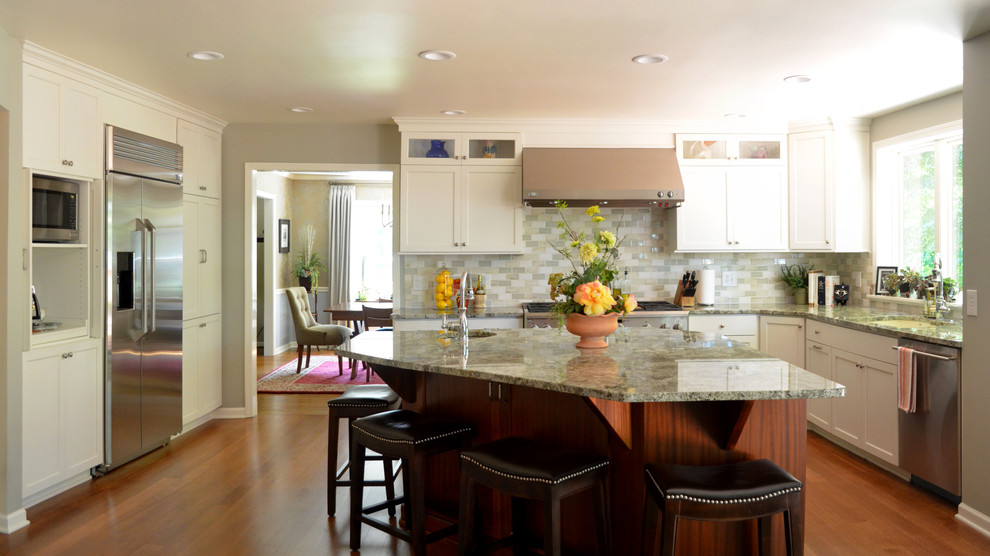 Transitional u-shaped medium tone wood floor eat-in kitchen photo in New York with shaker cabinets, white cabinets, granite countertops, green backsplash, an island, subway tile backsplash, stainless steel appliances and a double-bowl sink
