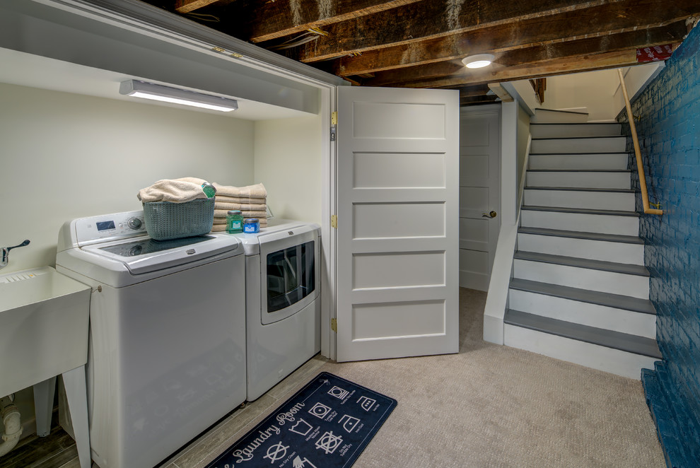 Inspiration for a small transitional single-wall laundry cupboard in DC Metro with an utility sink, blue walls, carpet and a side-by-side washer and dryer.