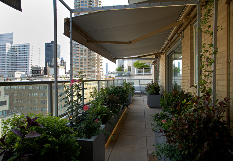 Inspiration for a large contemporary rooftop deck in New York with an awning.