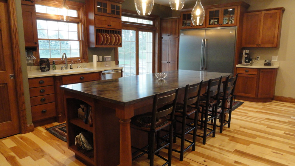 Large transitional l-shaped light wood floor and beige floor open concept kitchen photo with a double-bowl sink, shaker cabinets, medium tone wood cabinets, stainless steel appliances and an island