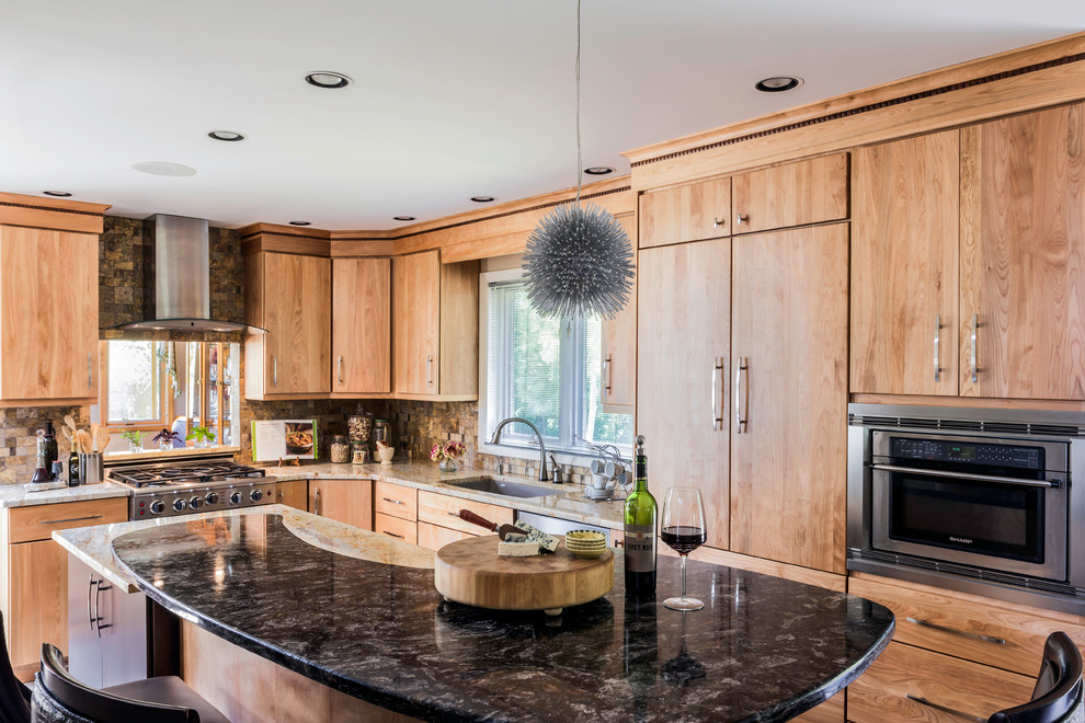 Photo of a mid-sized contemporary l-shaped eat-in kitchen in New York with flat-panel cabinets, light wood cabinets, granite benchtops, multi-coloured splashback, stone tile splashback, stainless steel appliances, ceramic floors, with island and a single-bowl sink.