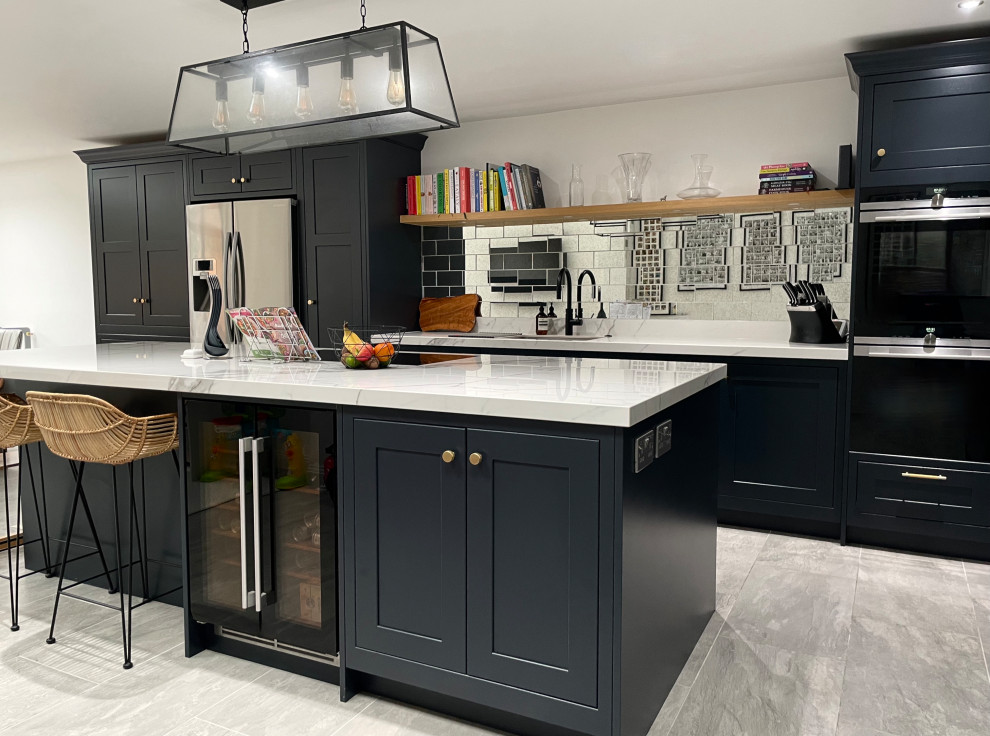 Large contemporary eat-in kitchen in London with shaker cabinets, grey cabinets and with island.