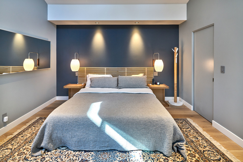 Inspiration for a mid-sized contemporary master bedroom in San Francisco with blue walls and light hardwood floors.