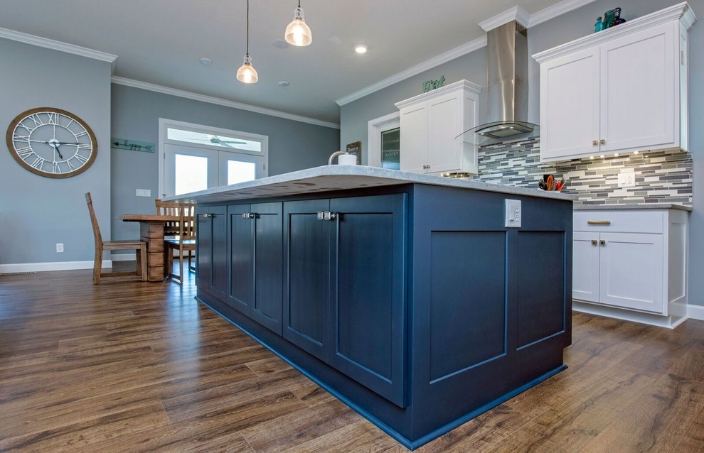Example of a mid-sized transitional single-wall dark wood floor and brown floor enclosed kitchen design in Columbus with a farmhouse sink, shaker cabinets, white cabinets, granite countertops, multicolored backsplash, matchstick tile backsplash, stainless steel appliances, an island and gray countertops